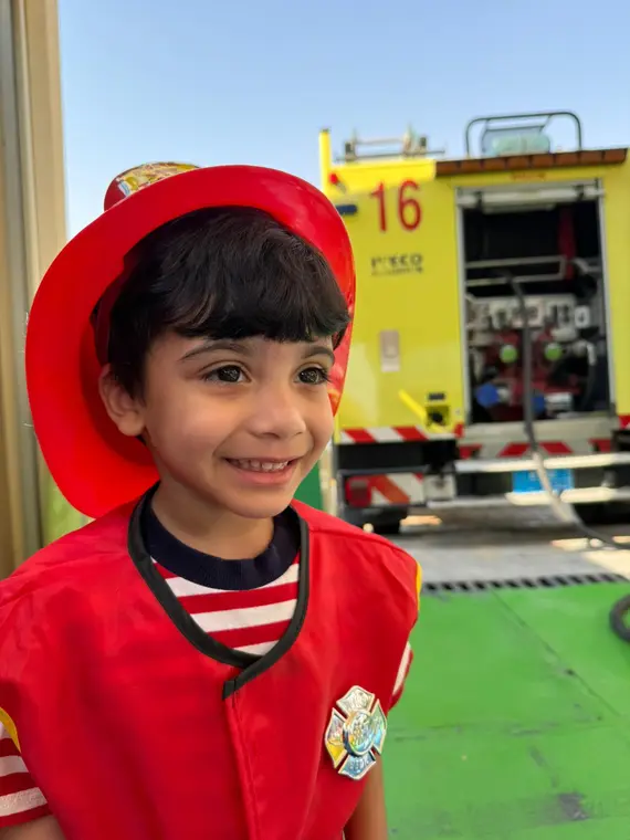 Child dressed as a firefighter on Civil Defence Day